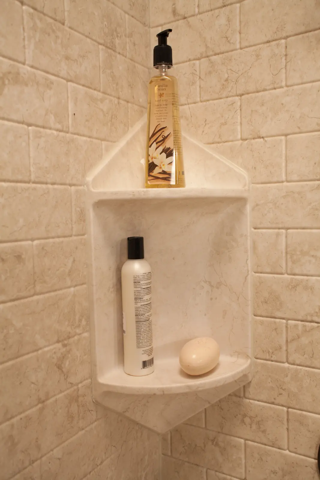 Brecchia two-shelf corner caddy close-up with subway tile walls