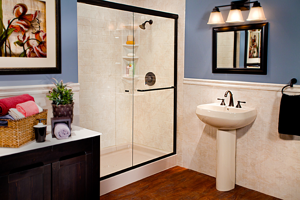 Walk-in shower with wainscoting, pedestal sink, and oil-rubbed bronze accents